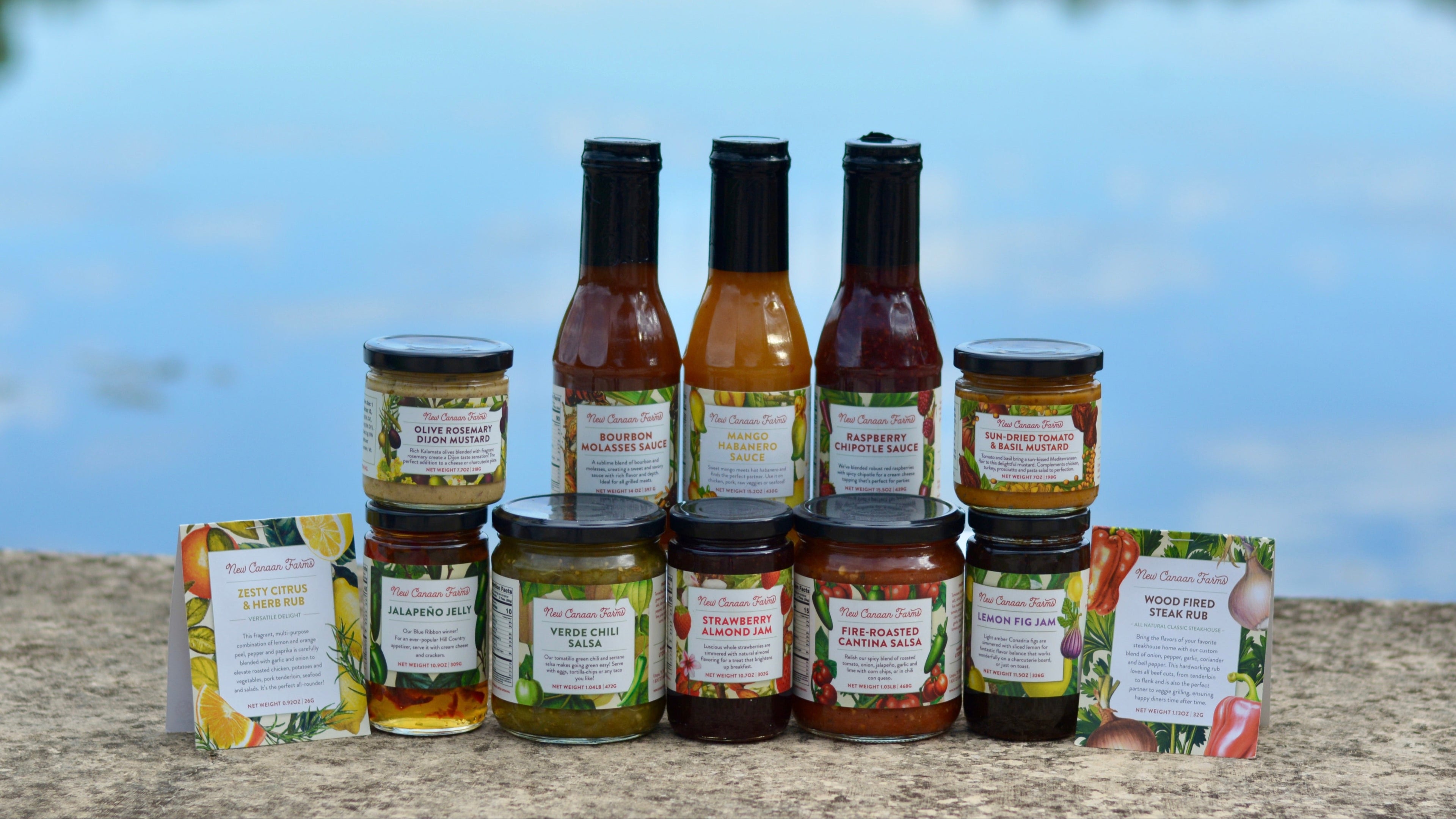 Assorted jars and bottles of sauces, mustards, jelly, salsa, and rubs.